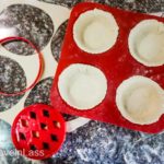 Cut small circles of dough and gently tuck them into the tart molds. (Fresh Raspberry Tarts)