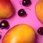 Three Mangos Five Black Cherries on Bright Pink Background (PORTFOLIO – Dyanne Kruger)